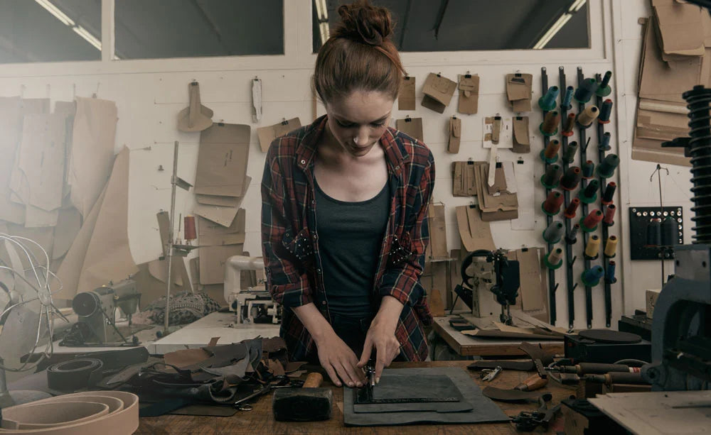 Person working in leather bond workshop with tools and materials around